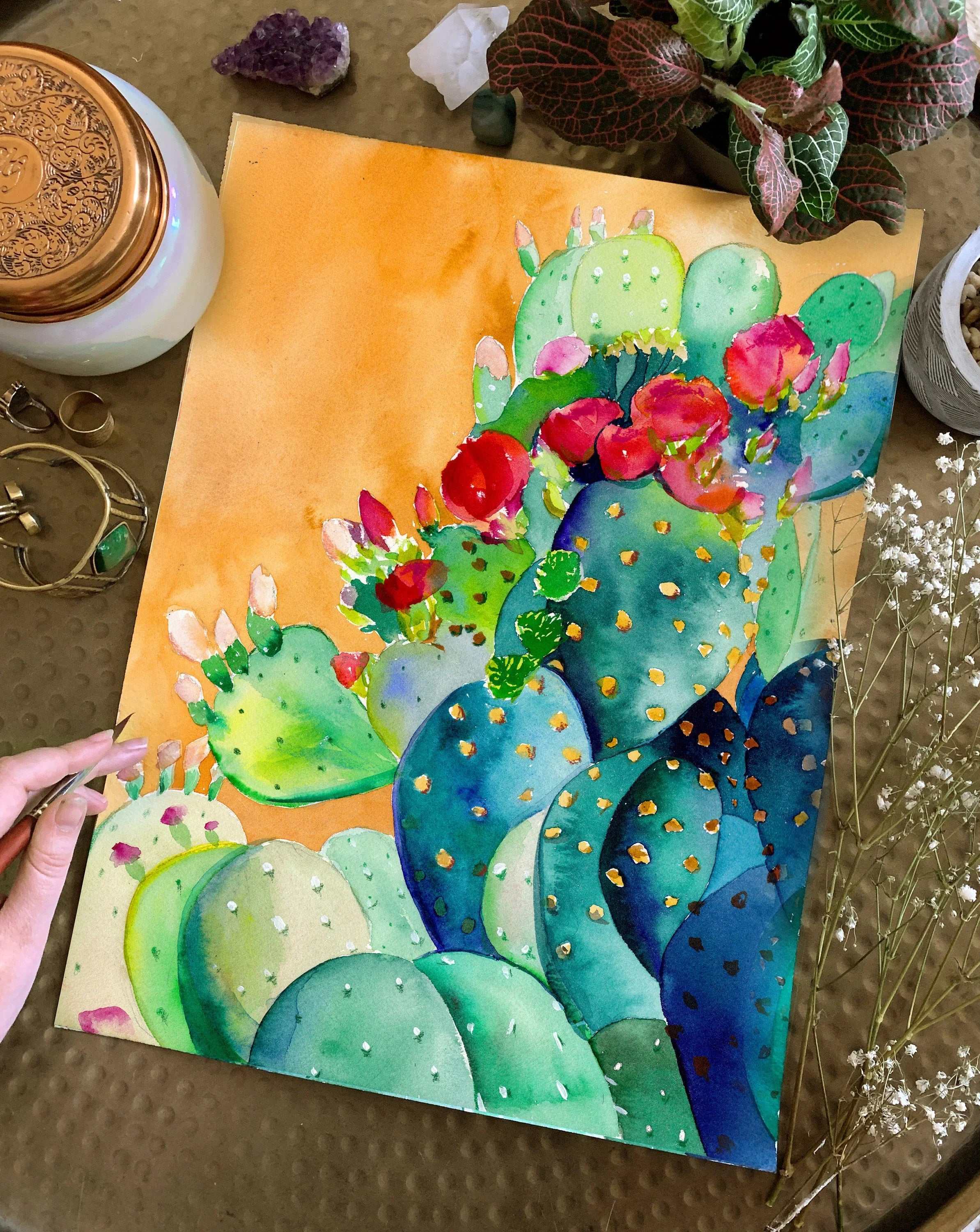 vibrant Cactus Garden Art Print featuring colorful cactus plants with red flowers on warm yellow background, surrounded by decorative items and plants